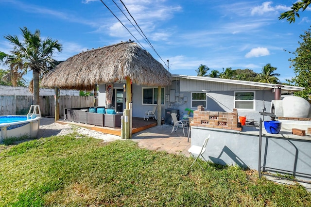 rear view of house with a fenced in pool, a patio area, outdoor lounge area, and a yard