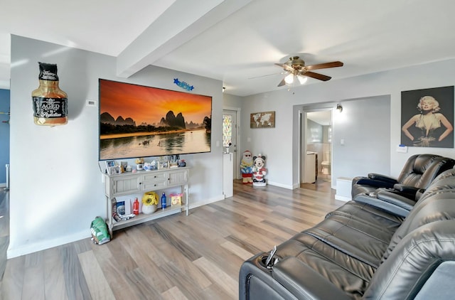 living room featuring ceiling fan, beamed ceiling, and light wood-type flooring