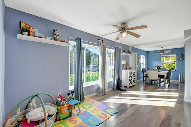 recreation room featuring hardwood / wood-style floors, ceiling fan, and a healthy amount of sunlight