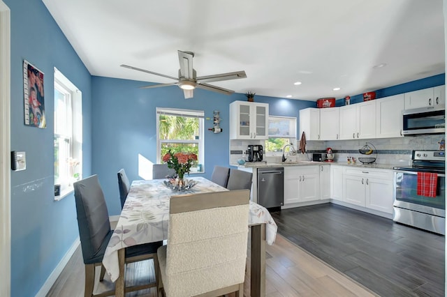 kitchen featuring white cabinets, appliances with stainless steel finishes, backsplash, and dark hardwood / wood-style flooring