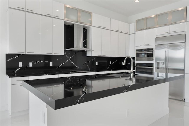 kitchen featuring sink, an island with sink, appliances with stainless steel finishes, tasteful backsplash, and white cabinetry