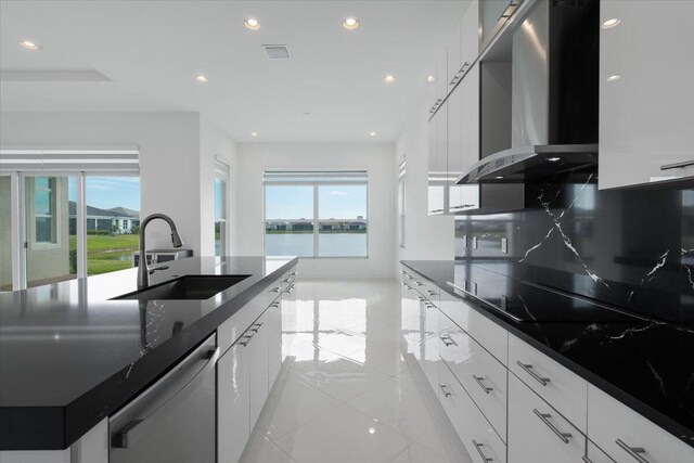 kitchen featuring white cabinets, a water view, and wall chimney exhaust hood