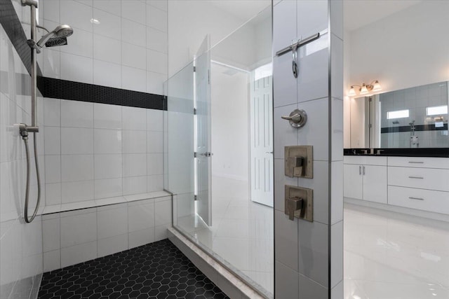 bathroom featuring a tile shower, tile patterned flooring, and vanity