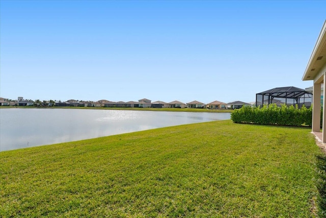 view of yard featuring glass enclosure and a water view