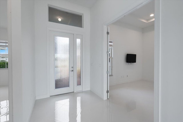 tiled entryway featuring french doors and a raised ceiling