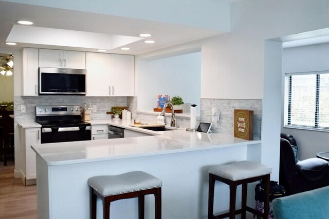 kitchen featuring backsplash, a sink, and white cabinetry