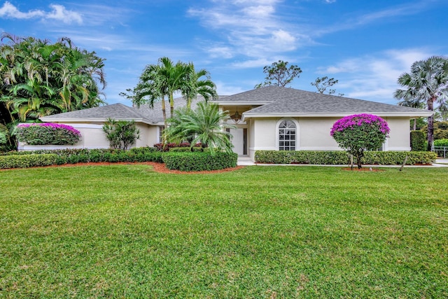 single story home featuring a front lawn and stucco siding