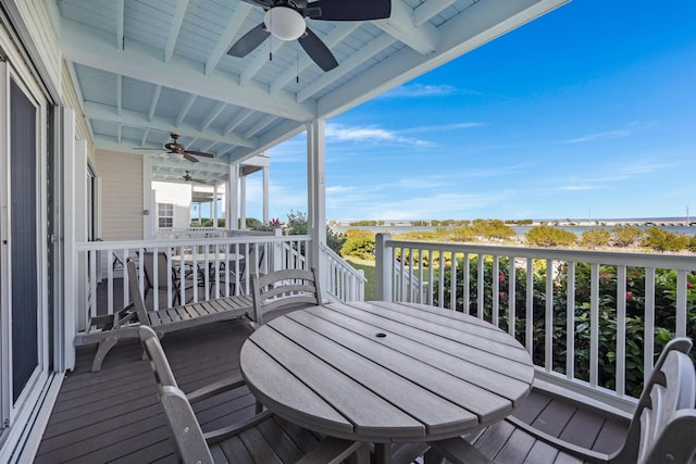 wooden terrace with outdoor dining space and a ceiling fan