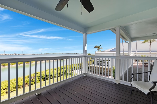 wooden terrace with a water view and ceiling fan