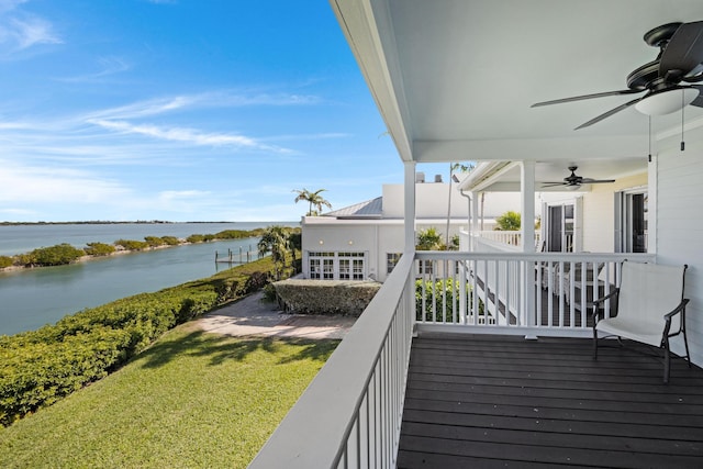 wooden terrace with a water view and ceiling fan