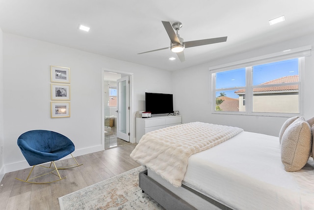 bedroom featuring connected bathroom, light hardwood / wood-style floors, and ceiling fan