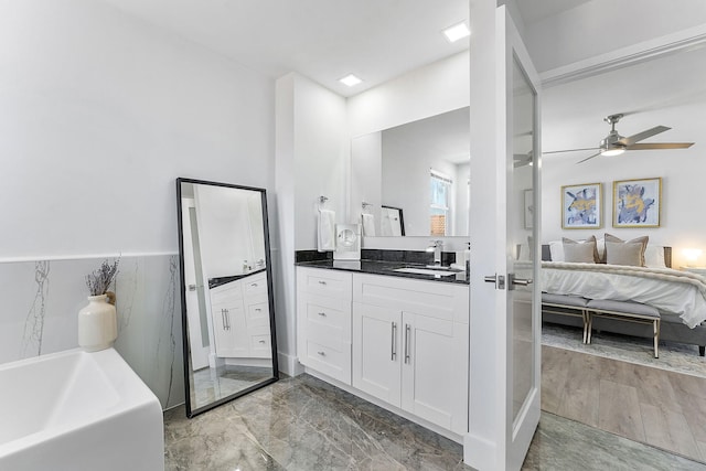 bathroom featuring a tub, ceiling fan, and vanity