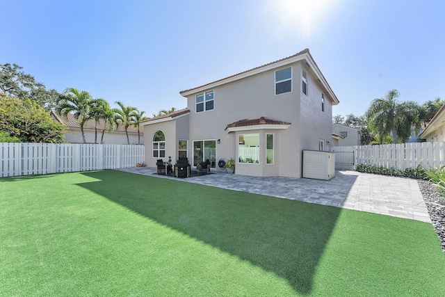 rear view of house featuring a yard and a patio