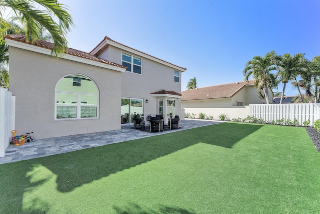 back of property featuring a patio area and a lawn