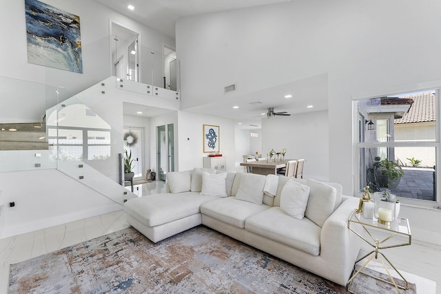 living room featuring ceiling fan and a high ceiling