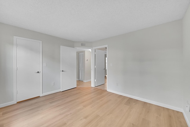 interior space with a textured ceiling and light hardwood / wood-style flooring