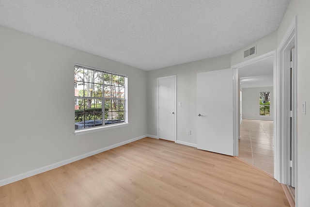 unfurnished bedroom featuring a textured ceiling and light hardwood / wood-style flooring