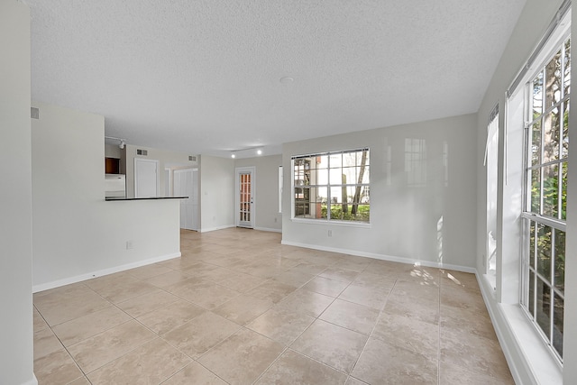 tiled spare room with a textured ceiling