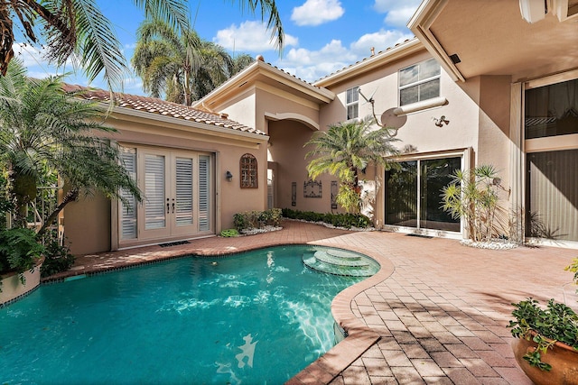 view of pool with french doors and a patio