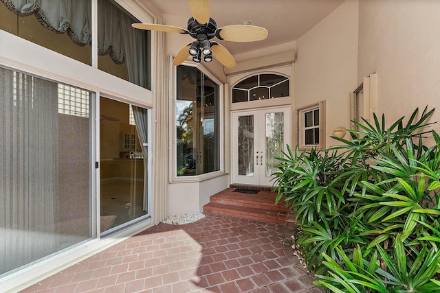 view of exterior entry featuring ceiling fan and french doors