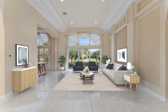 tiled living room with a towering ceiling and ornamental molding