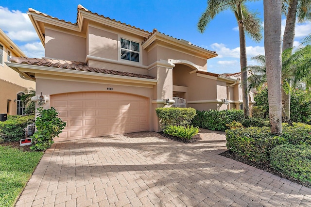 mediterranean / spanish-style house featuring central air condition unit and a garage