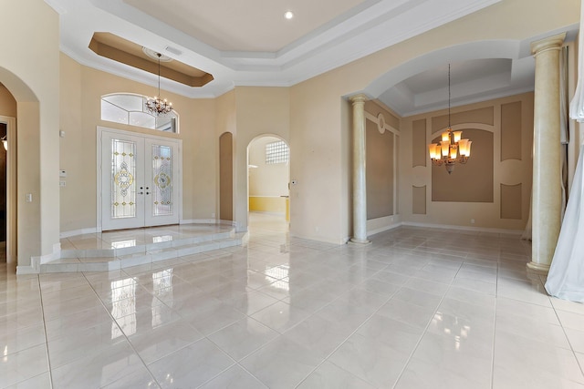 entryway featuring a tray ceiling, french doors, a chandelier, and ornamental molding