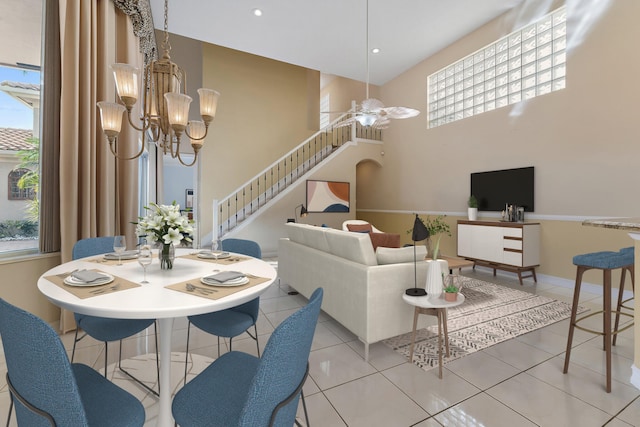 tiled dining room with plenty of natural light and ceiling fan with notable chandelier