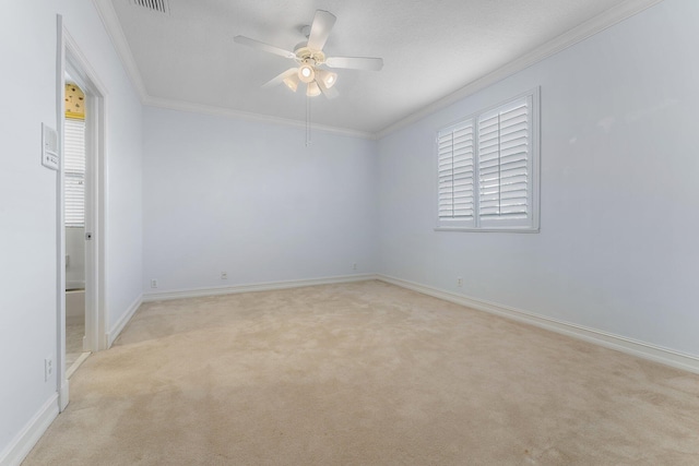 empty room with ceiling fan, crown molding, and light carpet