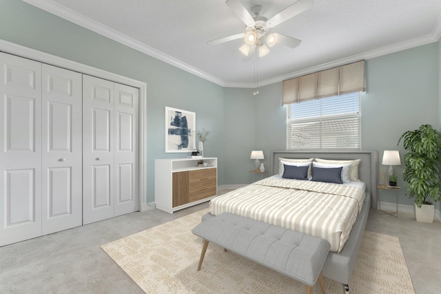 bedroom with light carpet, a textured ceiling, ceiling fan, crown molding, and a closet