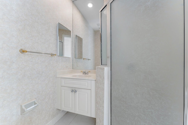 bathroom featuring tile patterned flooring, vanity, and a shower with door