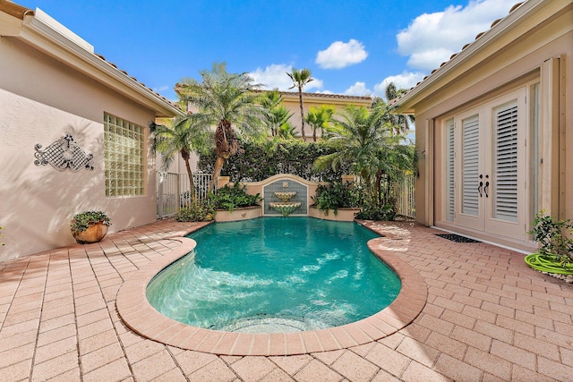 view of swimming pool with french doors and a patio area