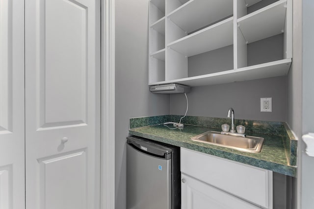 interior space with white cabinets, dishwasher, and sink