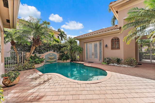 view of swimming pool featuring french doors and a patio