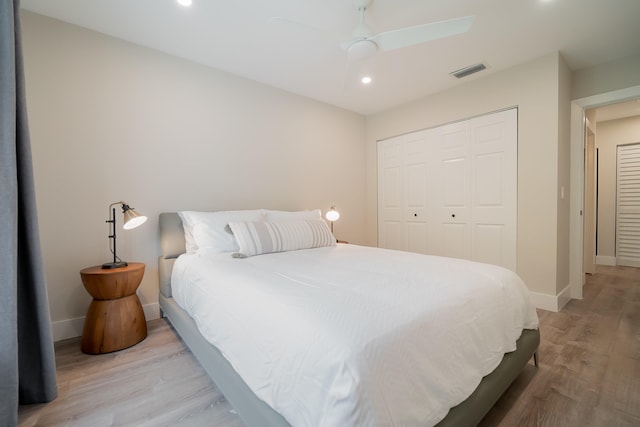 bedroom with ceiling fan, light hardwood / wood-style flooring, and a closet