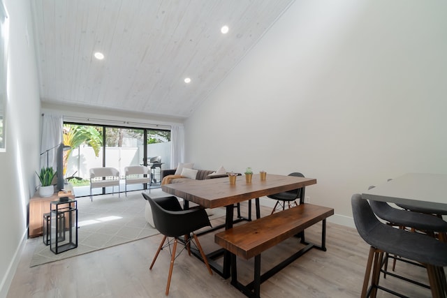 dining area with light hardwood / wood-style floors and vaulted ceiling