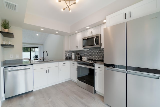 kitchen with stainless steel appliances, sink, light hardwood / wood-style flooring, an inviting chandelier, and white cabinetry