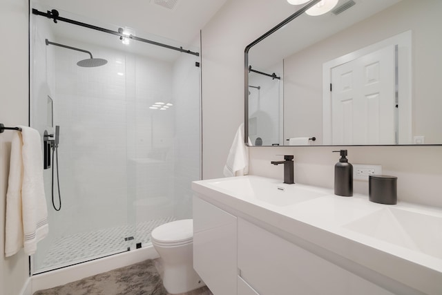 bathroom featuring vanity, a shower with shower door, and toilet