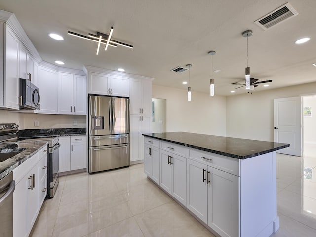 kitchen featuring ceiling fan, stainless steel appliances, white cabinets, and a kitchen island