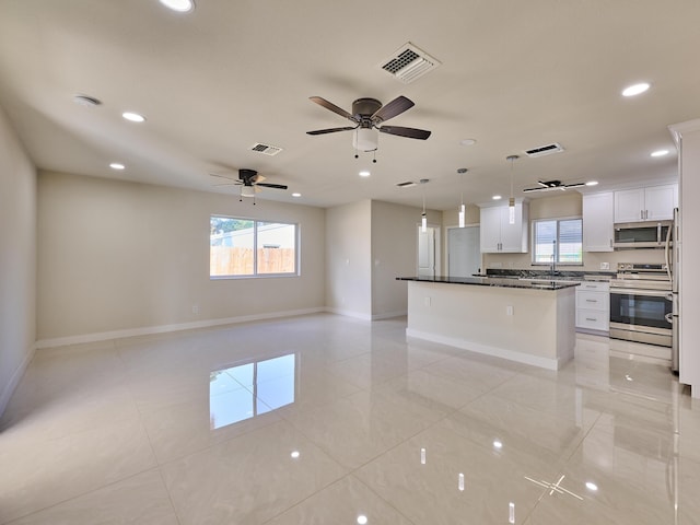 kitchen with stainless steel appliances, decorative light fixtures, white cabinetry, a center island, and ceiling fan