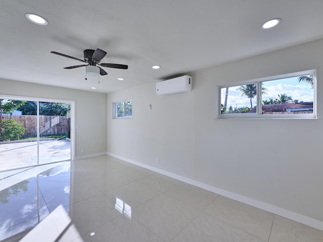 spare room with a wall mounted AC, ceiling fan, and light tile patterned floors