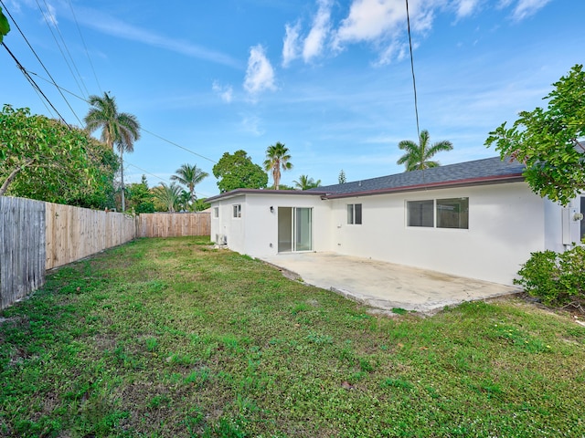 back of property featuring a yard and a patio