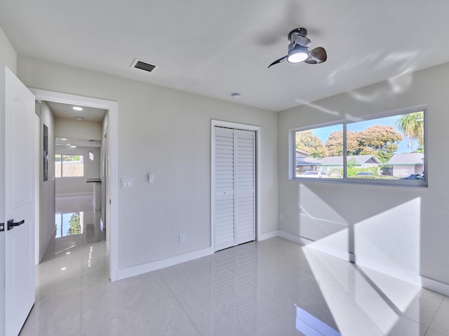 unfurnished bedroom featuring a closet, ceiling fan, and light tile patterned floors