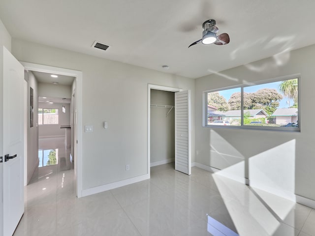 tiled bedroom with ceiling fan and a closet