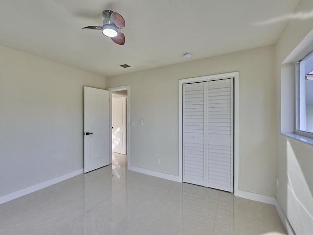 unfurnished bedroom featuring ceiling fan and a closet