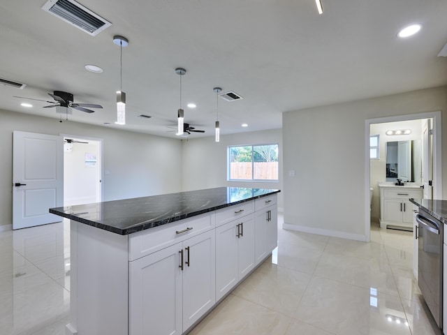 kitchen with white cabinets, pendant lighting, dark stone counters, and a center island