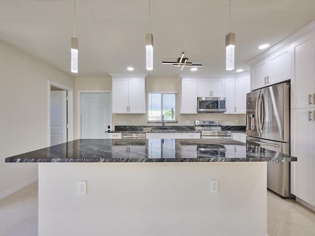 kitchen with stainless steel appliances, a kitchen island, white cabinets, and hanging light fixtures