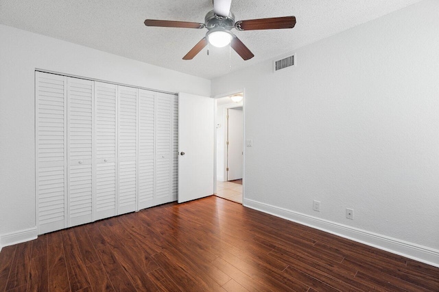 unfurnished bedroom featuring hardwood / wood-style floors, a textured ceiling, a closet, and ceiling fan