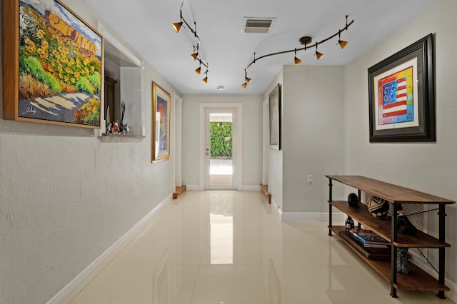 hallway with light tile patterned floors and track lighting