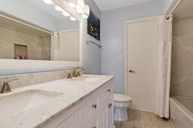 full bathroom featuring vanity, hardwood / wood-style floors, shower / tub combo with curtain, and toilet